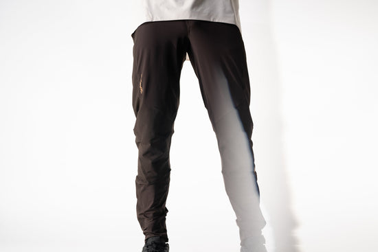 Person wearing dark pants and shoes on a white background